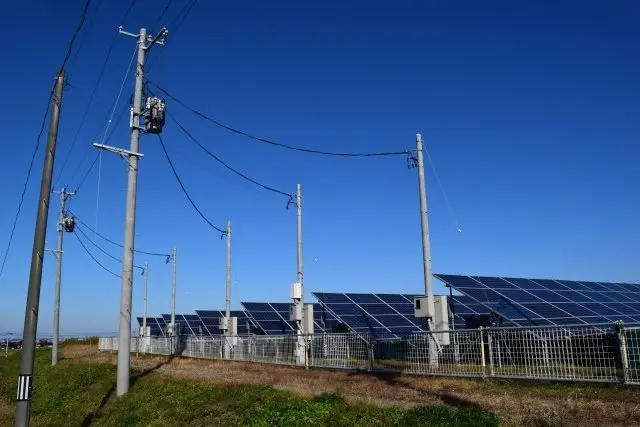 太陽光発電所の電柱とソーラーパネルの写真